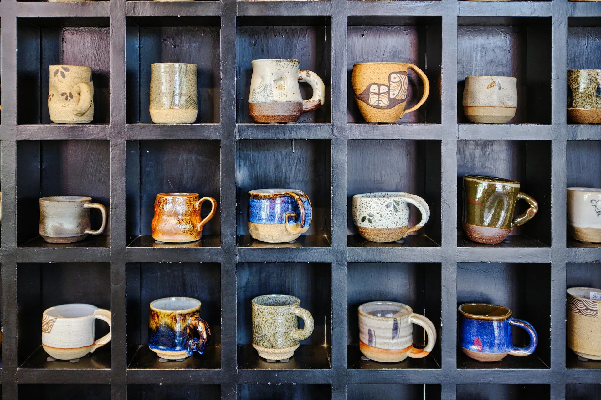 Assorted color mugs on a wooden rack