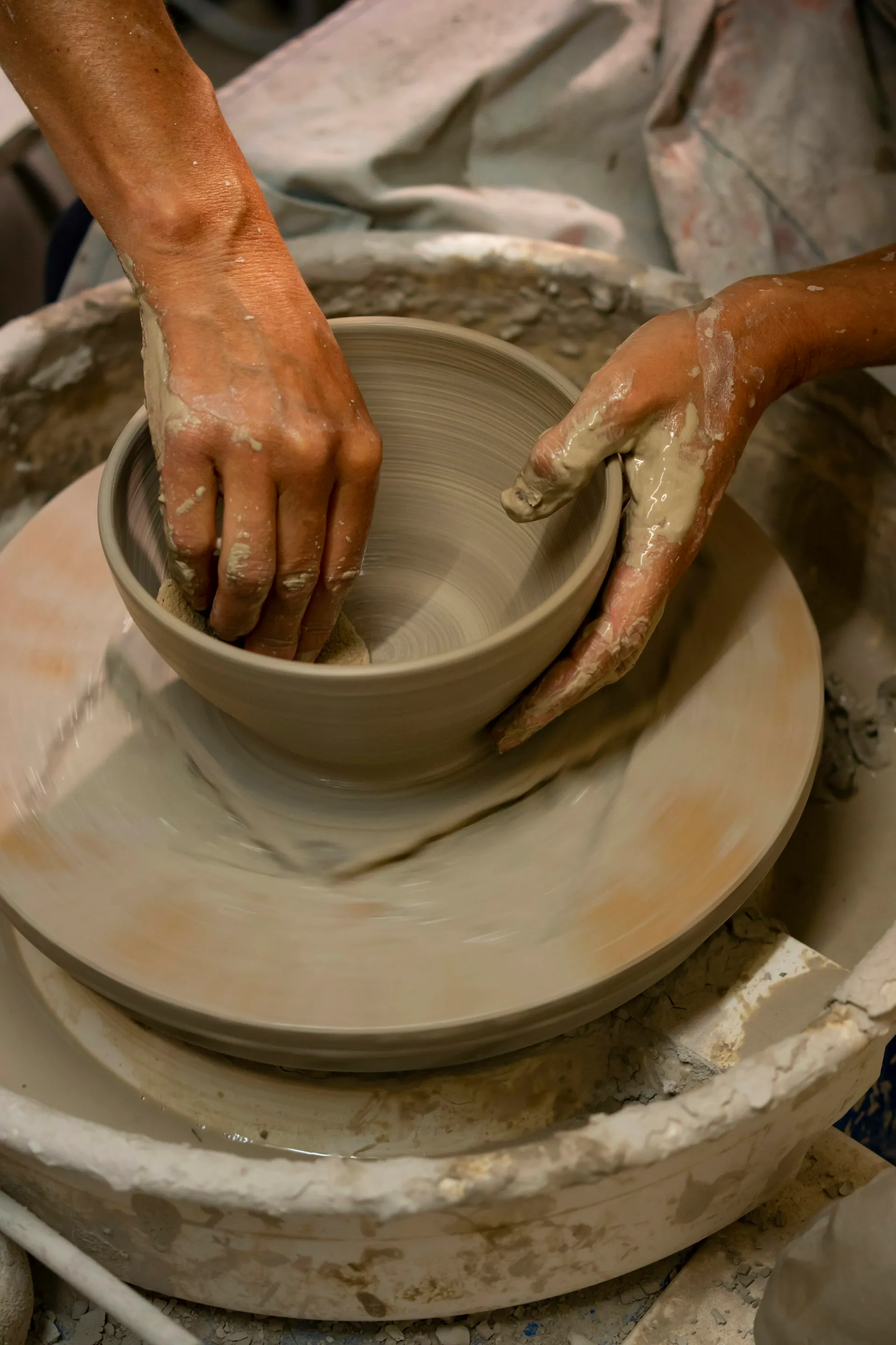 A person making a bowl on a potter's wheel