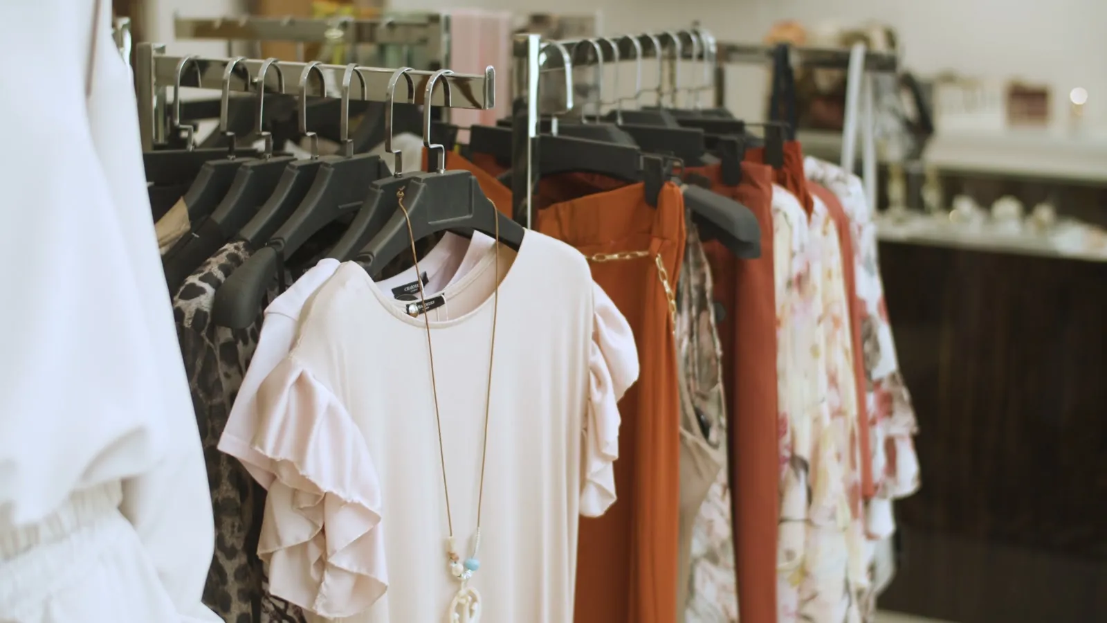 Clothing rack in a small boutique, slowly panning across the rack