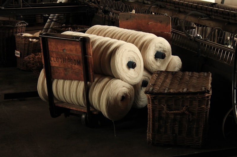 Rolls of yarn sitting on top of a wooden cart