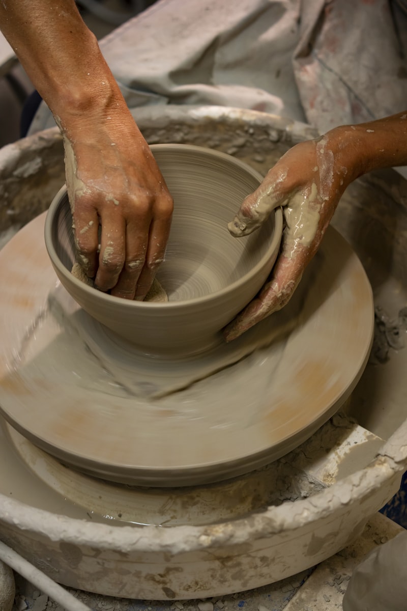 A person making a bowl on a potter's wheel